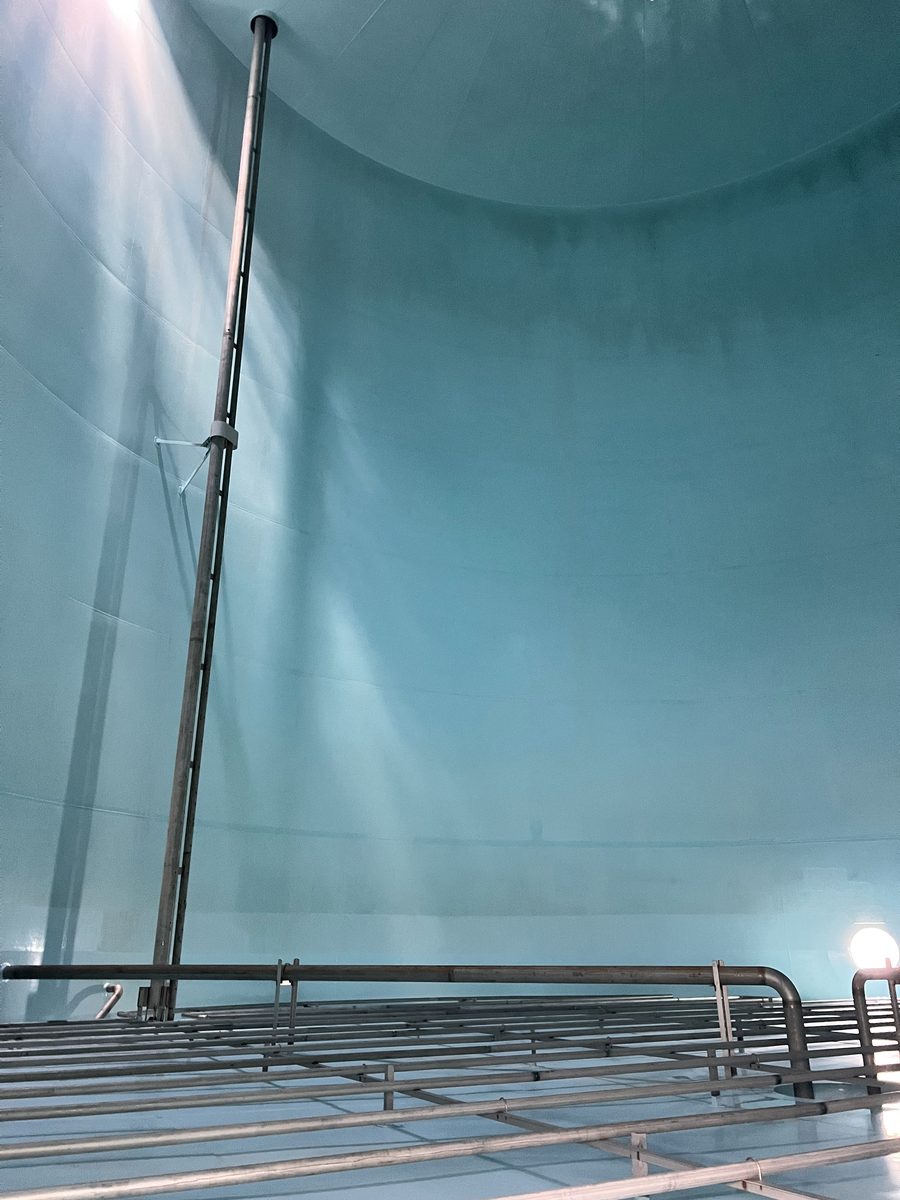 Binnenzijde van een opslagtank met lichtblauwe tank lining op wand, dak en verwarmingsspiralen
